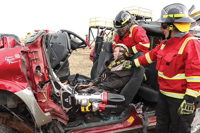 After peeling the roof off a vehicle, the jaws of life are used to free a drivers legs that are crushed.<br />

